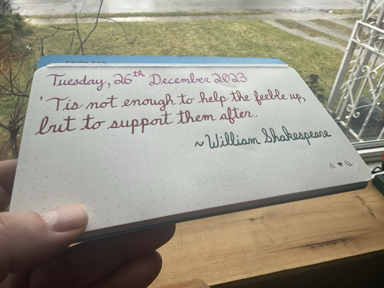 A pen quote written in Diamine Polar Glow, Diamine Noel and Pelikan Edelstein Olivine that reads, “‘Tis not enough to help the feeble up, but to support them after.” A quote from William Shakespeare.