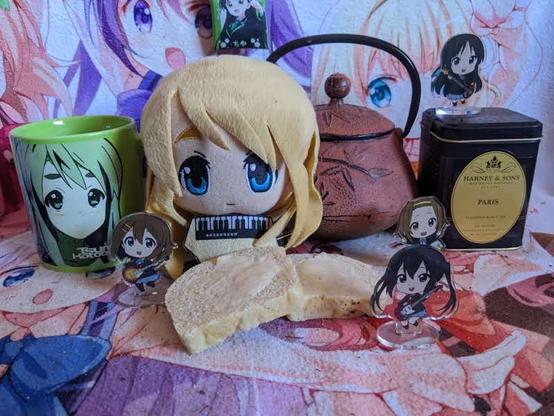 Mugi plushie and Kon! standees with tea and bread.