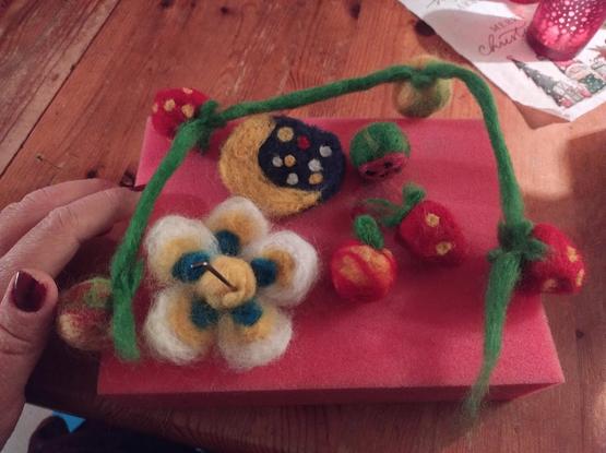 A flower, a moon and different fruits on my felting surface.
