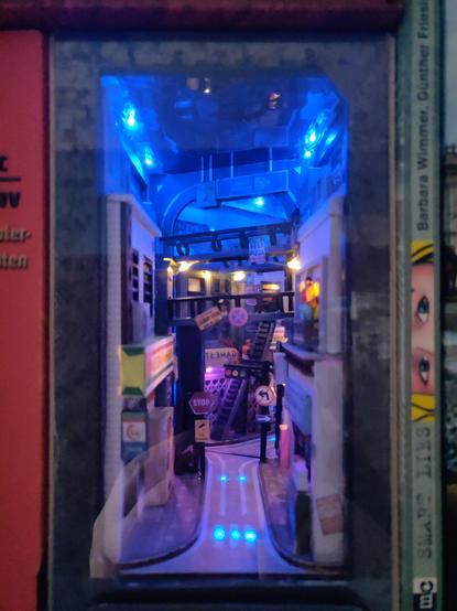 Gezoomte Durchsicht in die Straßenszene von vorne, alle led sind am Leuchten. Mit Staubschutz, links daneben steht das Buch Roboter Geschichten von Isaac Asimov.