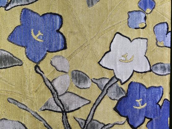 Gros plan sur des fleurs bleues et blanches sur fond jaune.