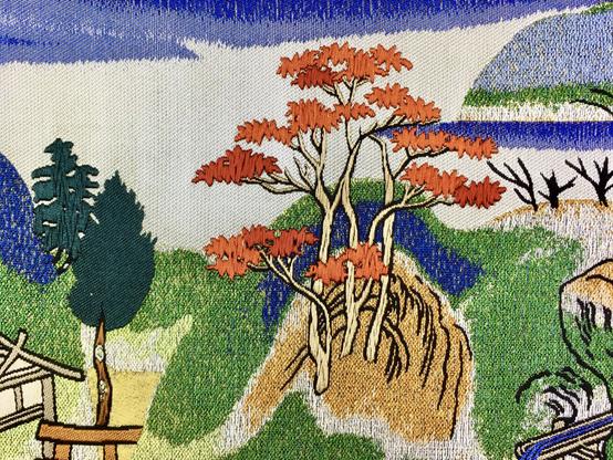 Scène paysagère tissée.
Gros plan sur un érable du Japon à feuilles rouges.