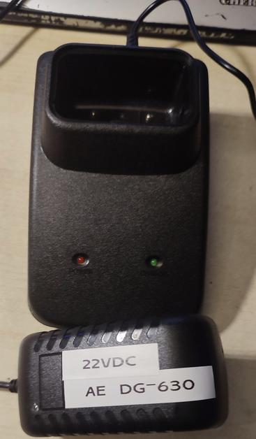 Photo showing a wall-wart power plug and a charging cradle. The wall power adapter has been marked with "22VDC" and "AE DG.630"