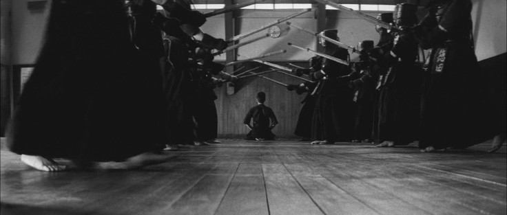 One of the kendōka kneeled on the floor in gruelling punishment, facing the clock on the wall, while the other students continue their training. The gorgeous cinematography is by Chikashi Makiura.