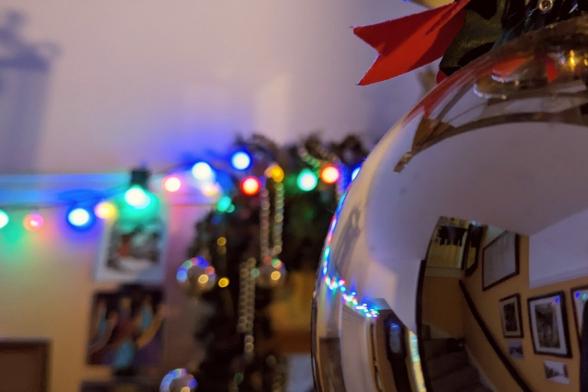 Fairy lights from the background reflected off a decorative bauble.