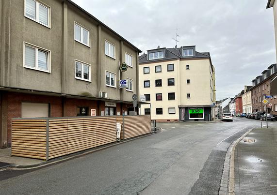 Links sind zwei Elemente mit je 5 Fahrradboxen mit ihren hölzernen Rückseiten vor einer Bude zu sehen.