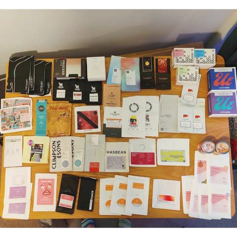 A photo of 55 empty coffee bags/boxes spread out on a table