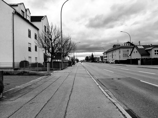 Eine leere vierspurige Straße, umgeben von Wohnhäusern.