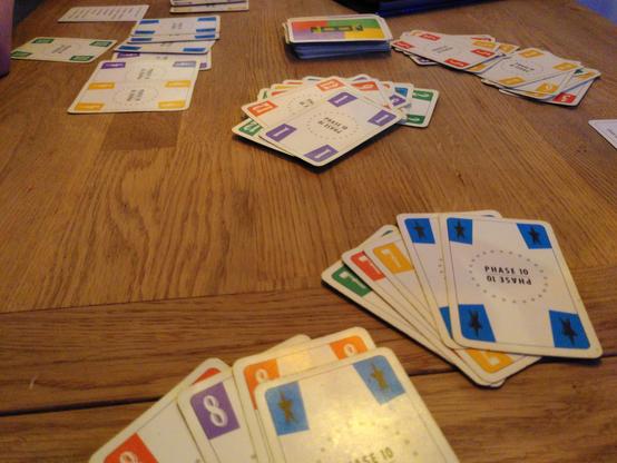 Spieltisch mit Kartenauslage des Spiels Phase10 am Ende der letzten Runde.