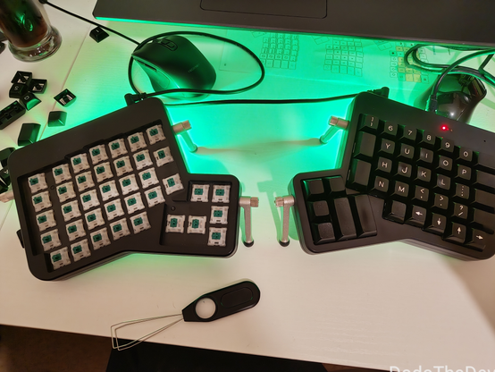 an Ergo Dox EZ by ZSA (a split matrix layout keyboard) where the left side has no keycaps and the switches have been changed to milky green switches (from plain brown) and the right side is yet to be changed.