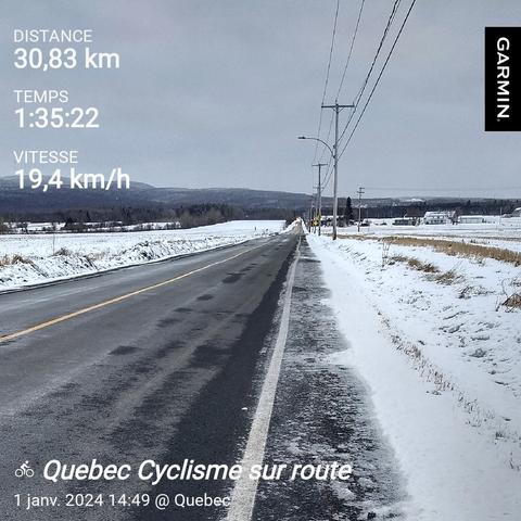 [fr]Une route en droite ligne vers l'horizon, des champs enneigés de chaque côté, et des montagnes à l'arrière-plan. [en]A road going straight towards the horizon. Snow covered fields on each side, with mountains in the background.
