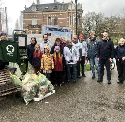 Groepsfoto van PvdD'ers die poseren bij afvalzakken.