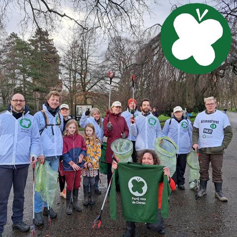 Groep mensen in PvdD kleding met grijpers en afvalzakken.