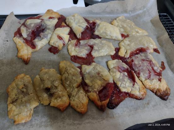 Photo of some under puffed but cooked puff pastry with jam oozing out.

Essentially a tray of flattened Jam Croissants on a baking sheet.