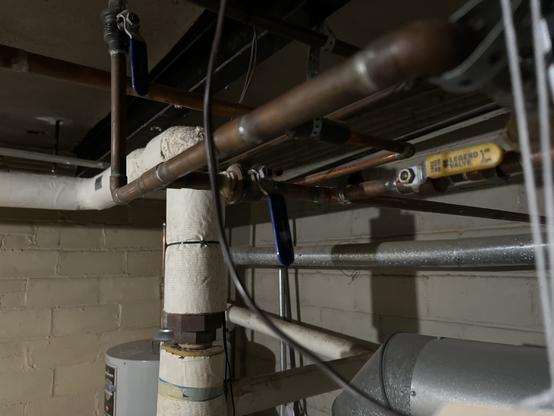 Three ball valves controlling the water fill: the main valve on the top left (blue) is open. The bypass valve in the middle (blue) is closed. The fill unit valve on the right (yellow) is open.