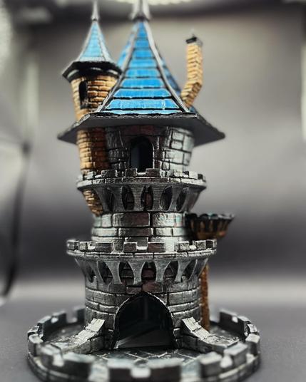 A front facing view of a 3d printed dice tower that is made to look like a miniature castle with a blue roof.