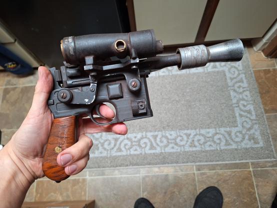 Right profile view of a replica DL44 blaster with a large scope set along to top right side