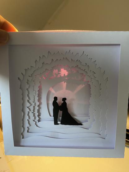 The same art with light behind showing a sun and rays silhouette with a purple tinge.