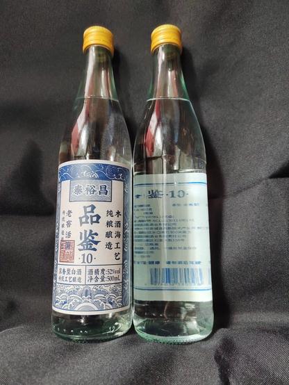 Two bottles of baijiu, one label-forward, one label-rearward to see both sides of the labelling.