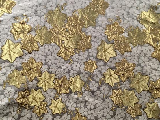 Motif de petites fleurs blanches et applications de feuilles d'or.