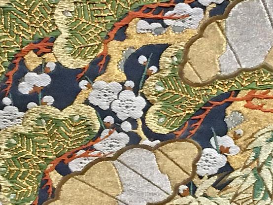 Décor d'éventails à motifs fleuris, dans des coloris vert et vermillon, avec des fils d'or.