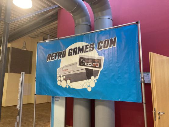 Ein großes Retro Games Con-Banner neben der Eingangstür.