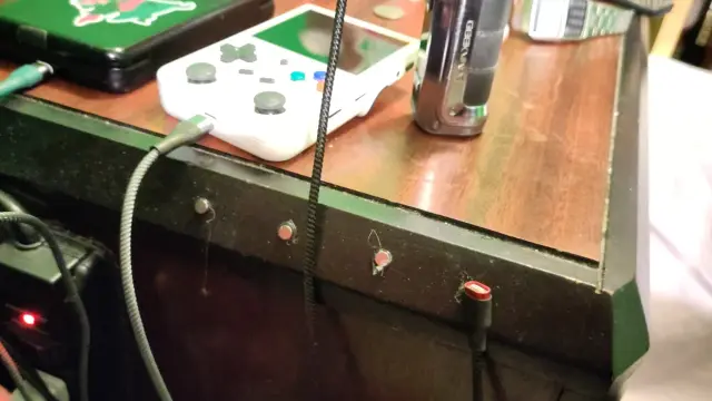 A pinephone, retro emulation handheld and vape are on my nightstand; four little round magnets are glued sloppily to the edge and one of them has a magnetic USB charger doodad stuck to it, because that's the one for my phone, which is not plugged in because it's in my hand now getting typed on