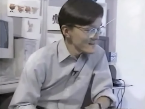 Screenshot from early part of video, showing Sonic creative staff with blurry artwork posted up behind them.