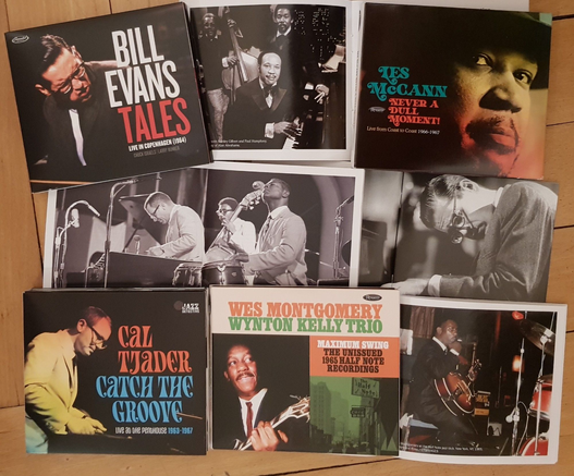Assembly of CDs and booklets on wooden floor:

Bill Evans – Tales. Live in Copenhagen (1964)
Les McCann – Never a Dull Moment. Live from Coast to Coast 1966–1967
Cal Tjader – Catch the Groove. Live at the Penthouse 1963–1967
Wes Montgomery/Wynton Kelly Trio – Maximum Swing. The Unissued 1965 Half Note Recordings