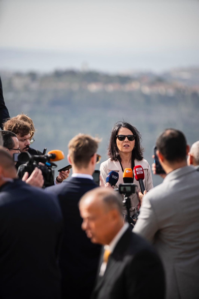 Außenministerin Baerbock spricht auf einer Anhöhe im Westjordanland in Kameras. Copyright Photothek.
