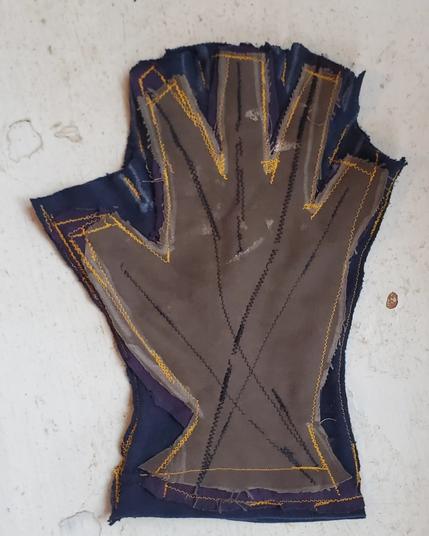 A fingerless glove stitched out together from rags. The top