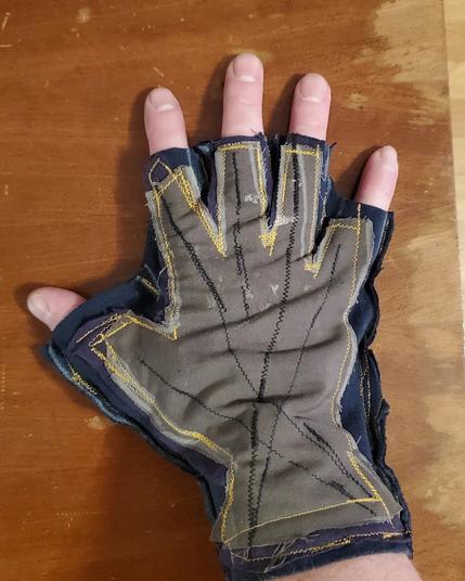 A fingerless glove stitched out together from rags. My fat hand in it.