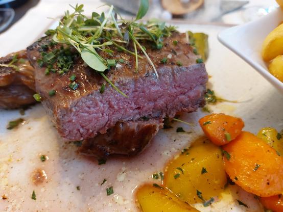 Rib-Eye-Steak, medium, auf glasierten Möhren und Steakhauspommes r/w