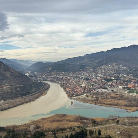 A confluence of two differrent-colored rivers between mountains