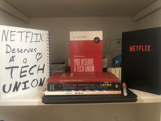 photo: a linen shelf with some books on Tech Unions, organizing in general, and couple of journal notebooks 📓. Everything is posed to be Instagram worthy, except for my potato lighting and the fact that I was squatting on a toilet as I took the photo. Because I’m classy.

[Left: a white journal propped up vertically; hand printing in  black marker written on the back cover]

NETFLIX
Deserves
⭐️    a    ❤️
TECH
UNION

[Center: a short stack of books]

- IDENTITY: Who We Are — Troll Publishing

- An AFRICAN and LATINX HISTORY of the UNITED STATES — Ortiz

- The TECH WORKERS GUIDE to UNIONS — Parrish

- YOU DESERVE a TECH UNION — Marcotte

[Left: a black hardback journal with the Netflix logo]