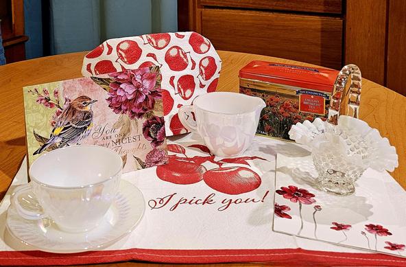 A tea tableau with an apple theme and white vintage glass.