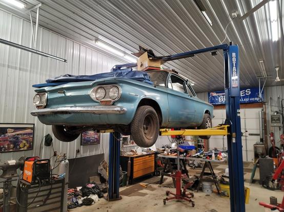 A 1964 Chevrolet Corvair on a vehicle lift