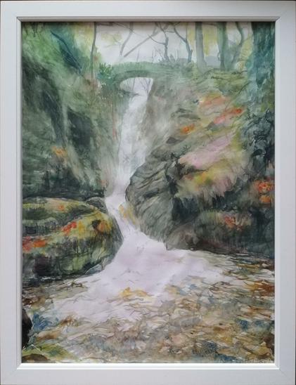 A framed watercolour painting of a small waterfall flowing towards a pool of water in the foreground.
