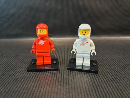 Deux figurines LEGO, du thème "Space". Une rouge et une blanche. Elles sont côte à côte.