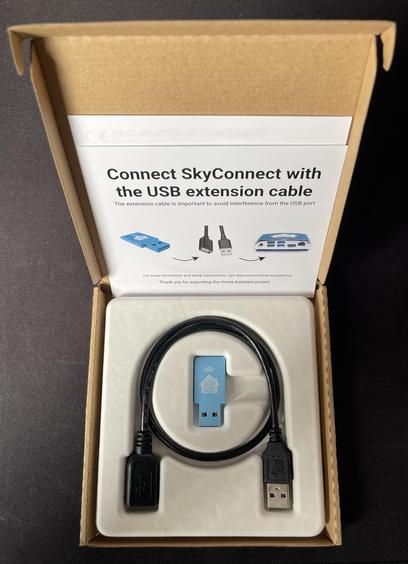 Caja de SkyConnect que contiene el propio pincho USB de SkyConnect, más un cable USB alargador y las instrucciones donde se puede leer:

Connect SkyConnect with
the USB extension cable
The extension cable is important to avoid interference from the USB port
For more information and setup instructions, visit skyconnect.home assistant.io
Thank you for supporting the Home Assistant project