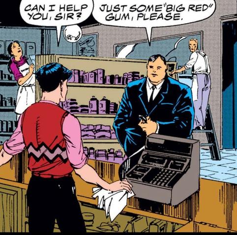 A heavyset man in a suit approaches a young man behind a cash register in what looks like an old fashioned local grocery store. A man and woman in the background are restocking shelves. "Can I help you, sir?" the young man asks. "Just some 'Big Red' gum, please," says the man, holding something unidentifiable in his hand.
