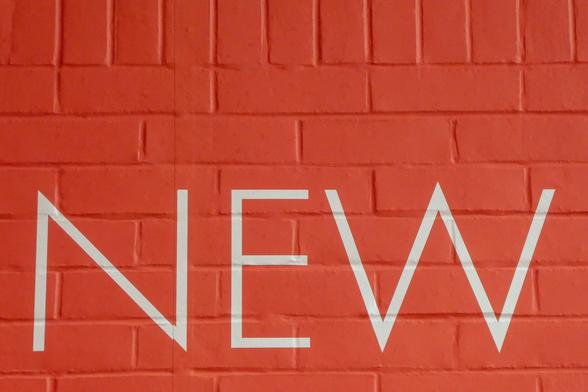 Red brick wall with the word 'new' painted in white. Photograph by Nick Fewings under an Unsplash free licence: bit.ly/3RNIuih