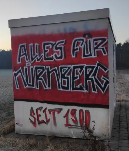 Auf der Seitenwand eines Transformatorhäuschens ist der Spruch "Alles für Nürnberg" zu lesen, in Anlehnung an eine Losung der SA. Offensichtlich von einem "Fan" des 1. FC Nürnberg erstellt.