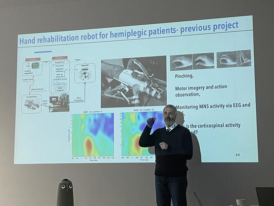Prof. Dr. Kutluk Arikan presenting his research during a Labtalk hosted by the Wagnerlab. Shown is a slide on a "Hand rehabilitation robot for hemiplegic patients" a previous project of Dr. Arikan.