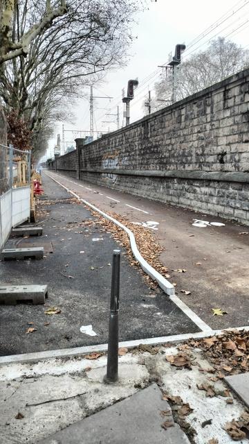 Un trottoir et une piste cyclable, tous les deux entièrement neuf, tracé de la voie lyonnaise 2 longeant le mur d'enceinte du parc de la tête d'or