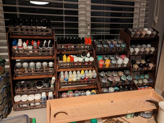 After: organised set of paints on paint racks on a desk