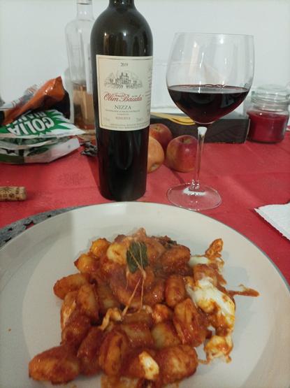 A dish of gnocchi with a glass of Nizza Riserva DOCG