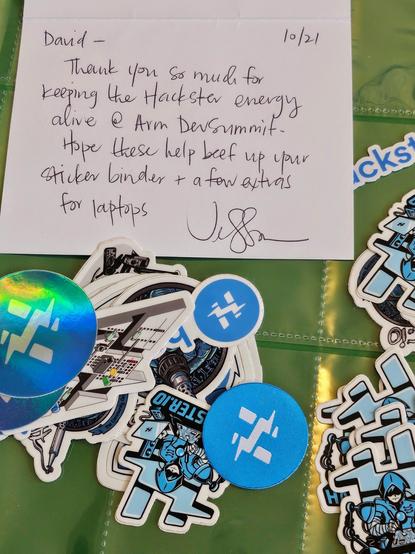a pile of Hackster stickers with a handwritten note from the CEO, Jessica 💙✨️