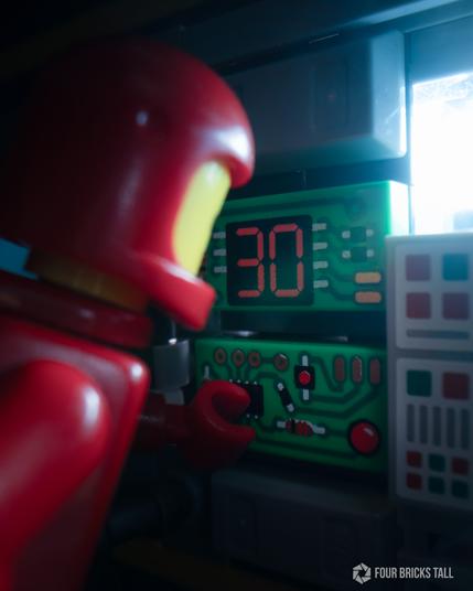 A close up of circuit boards. A LEGO classic spaceman is touching a module.