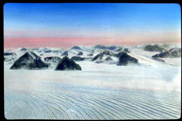 A photo of a snowy landscape with mountains in the background.